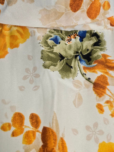 Floral dress with orange and green pattern on a mannequin