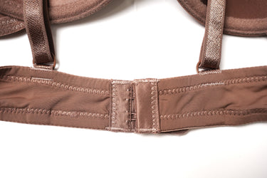 Close-up of a brown bra strap and underband with detailed stitching on a white background.